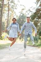 joven pareja enamorada divirtiéndose y disfrutando de la hermosa naturaleza de verano. mujer y hombre, vestidos con ropa de mezclilla, tienen una cita al aire libre en el parque. relación romántica. día de San Valentín foto