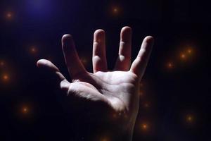 man hand up gesturing in the shadows, dark background photo