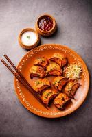 Tandoori momo, veg or non veg in red and cream sauce, served with sauce.  Nepal and Tibet recipe photo