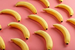 Geometric pattern of bananas on a pink background. photo