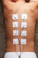 electrodos de mioestimulación en la espalda de una mujer para masaje y rehabilitación. foto