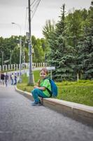 Portrait of a child, a boy against the backdrop of urban landscapes of skyscrapers and high-rise buildings in the open air. Children, Travel. Lifestyle in the city. Center, streets. photo