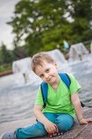 retrato de un niño, un niño en el contexto de paisajes urbanos de rascacielos y edificios de gran altura al aire libre. niños, viajes. estilo de vida en la ciudad. centro, calles. foto