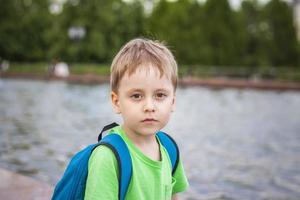 retrato de un niño, un niño en el contexto de paisajes urbanos de rascacielos y edificios de gran altura al aire libre. niños, viajes. estilo de vida en la ciudad. centro, calles. foto