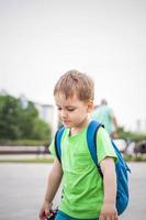 Portrait of a child, a boy against the backdrop of urban landscapes of skyscrapers and high-rise buildings in the open air. Children, Travel. Lifestyle in the city. Center, streets. photo