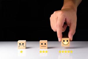 Customer service and Satisfaction feedback concept ,Business people show feedback with smile face wood cube happy Smiley face icon satisfaction in service. wood cubes rating. wood cubes ideas. photo