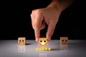 Customer service and Satisfaction feedback concept ,Business people show feedback with smile face wood cube happy Smiley face icon satisfaction in service. wood cubes rating. wood cubes ideas. photo