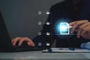 Document management system concept, business man using laptop search folder and document icon software, searching and managing files online document database, for efficient archiving and company data. photo
