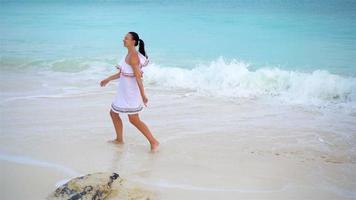 jong mooi vrouw Aan tropisch kust. bovenstaand visie van gelukkig meisje in mooi jurk Aan wit strand video