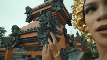 een balinees meisje wandelen naar de tempel voor bidden terwijl vervelend een rood goud kostuum video