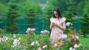 giovane ragazza nel un' fiore giardino tra bellissimo Rose. odore di Rose video