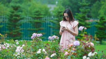 Young girl in a flower garden among beautiful roses. Smell of roses video