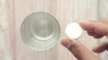 Man holding an effervescent soluble tablet pill over a glass of water video