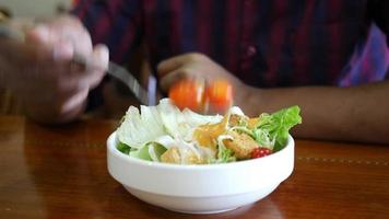 Eating caesar Salad in a bowl on table video