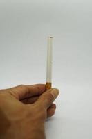 filtrar cigarrillos en mano y blanco antecedentes. foto