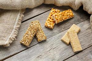 Assorted kozinaki, on old vintage background, with burlap fabric. Country style. Delicious sweets from the seeds of sunflower, sesame and peanuts, covered with shiny glaze. photo