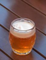 vaso de cerveza ligera en la mesa de madera. foto