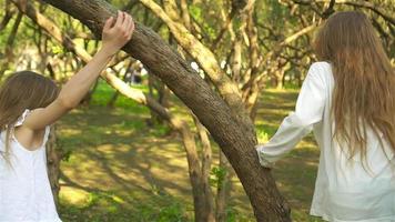 Cute girls in blooming apple tree garden enjoy the warm day video