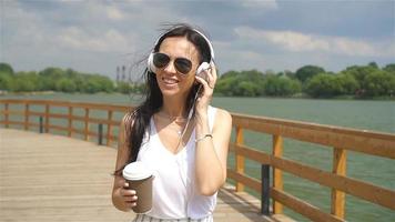Happy young urban woman drinking coffee in european city. video
