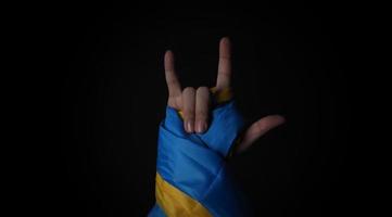 Russian flag and Ukraine flag in hands showing symbol of struggle war photo