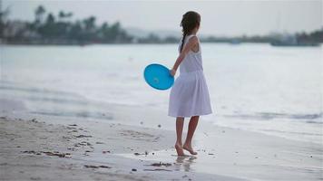 content fille en jouant avec en volant disque à plage video