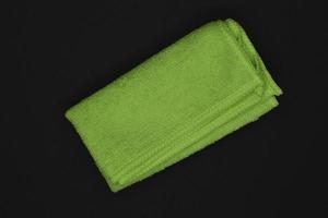 A green cloth for wiping. A terry towel. A rag for cleaning the premises. A green towel. photo