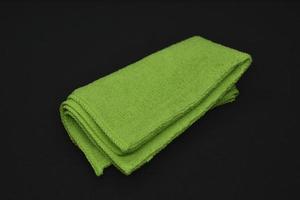 A green cloth for wiping. A terry towel. A rag for cleaning the premises. A green towel. photo