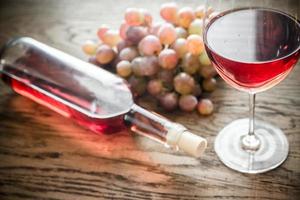 Glass of rose wine with bunch of grape photo