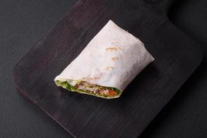 Delicious fresh roll with chicken, tomatoes, lettuce and cucumber in pita bread photo