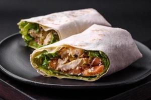 Delicious fresh roll with chicken, tomatoes, lettuce and cucumber in pita bread photo