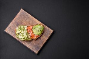 delicioso marrón un pan brindis con salmón, palta, Pepino y sésamo semillas foto