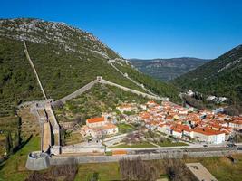 Aerial drone view of the fortified walls of the city Ston in Croatia. Tourism near the Adriatic sea. Historic visits. photo