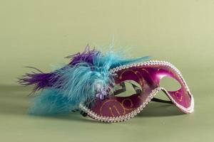 Venetian carnival mask with feathers, and typical elements in the background photo