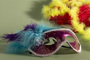 Venetian carnival mask with feathers, and typical elements in the background photo