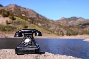 Vintage telephone on the rock photo