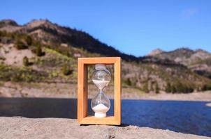 Hourglass on the rock photo