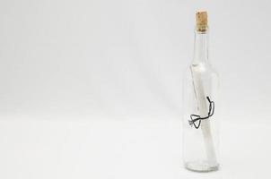 Glass bottle with letter on white background photo