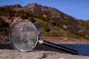 Magnifying glass on the rock photo