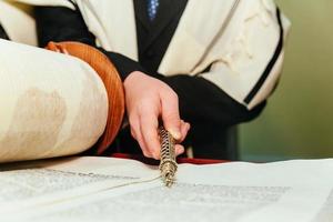 Hand of boy reading the Jewish Torah at Bar Mitzvah photo