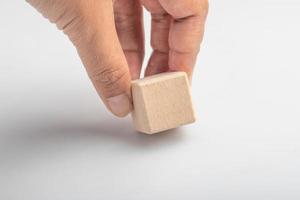 Hand picking up empty wooden square blocks on white background. photo
