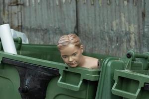 Mannequin head on the trash can. Consumer culture concept photo