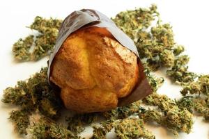 Coffee shop food containing THC. Muffin on cannabis buds. Medical marijuana use for selfcare photo