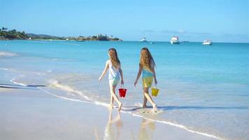adorables petites filles jouant avec du sable sur la plage. video
