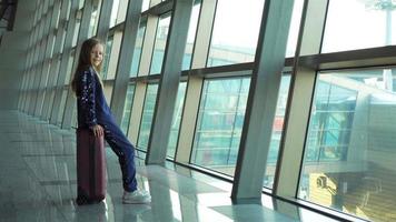 adorable niña en el aeropuerto con su equipaje esperando el embarque video