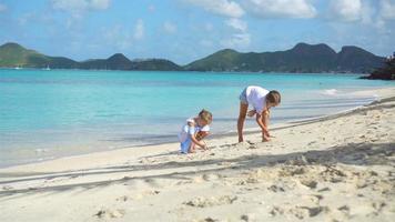 Two kids making sand castle and playing at tropical beach video