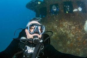 scuba divers inside a ship wreck photo