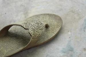 Women's sandals, faded and worn, isolated on gray and white photo