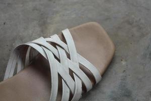 Women's sandals, faded and worn, isolated on gray and white photo