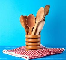 wooden spoons in a wooden container on a blue table photo