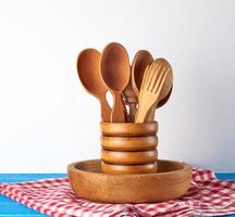 wooden spoons in a wooden container on a blue table, kitchen backdrop photo